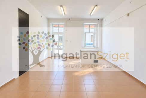 Világos, üres üzlethelyiség bejárattal